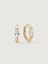 Gold hoop earrings with gemstones on a light beige background