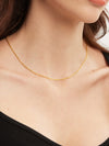 Gold necklace on a person wearing a black top