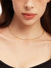 Close-up of a person wearing a gold chain with a blurred background