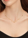 Gold necklace with small heart pendants on a person wearing a black top.