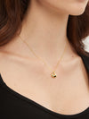 Gold necklace with a heart pendant worn by a person