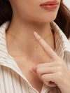 Gold necklace with a pendant worn by a person, pointing to it.