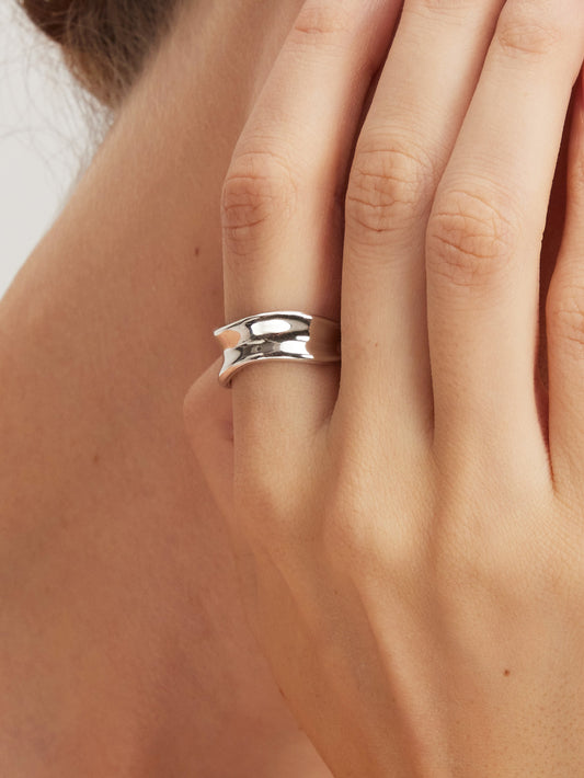 Silver ring on a person's finger with a blurred background