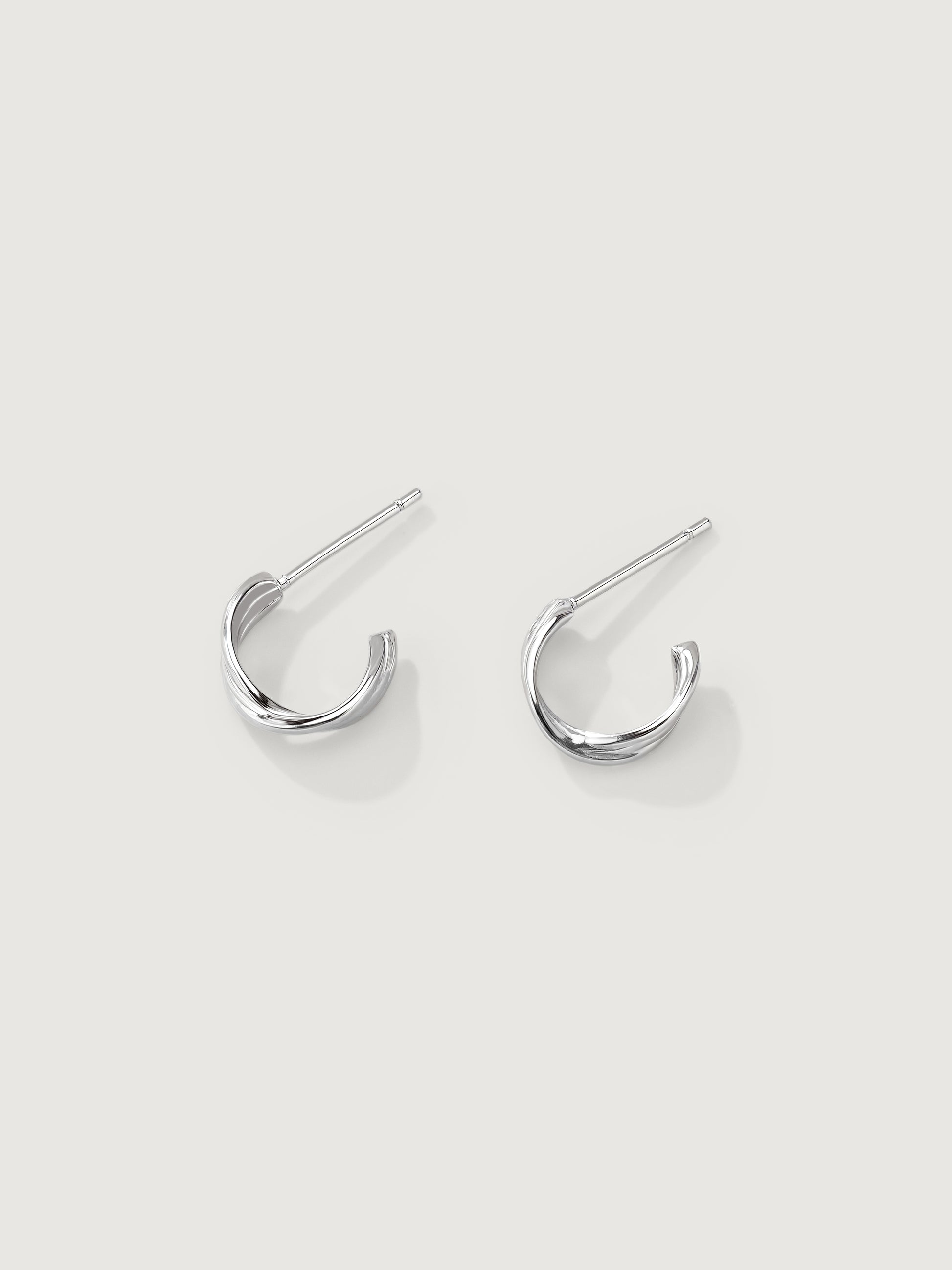 Pair of silver hoop earrings on a light gray background