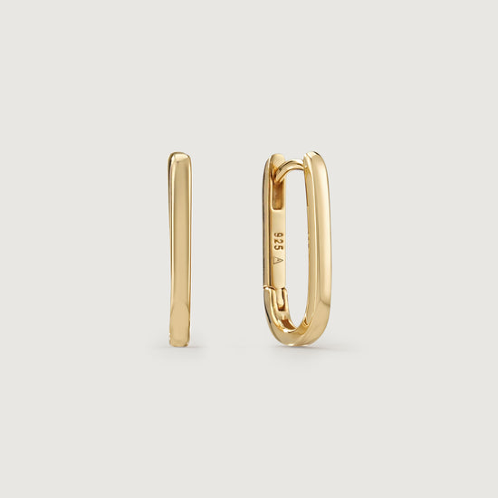 Gold hoop earrings on a light beige background