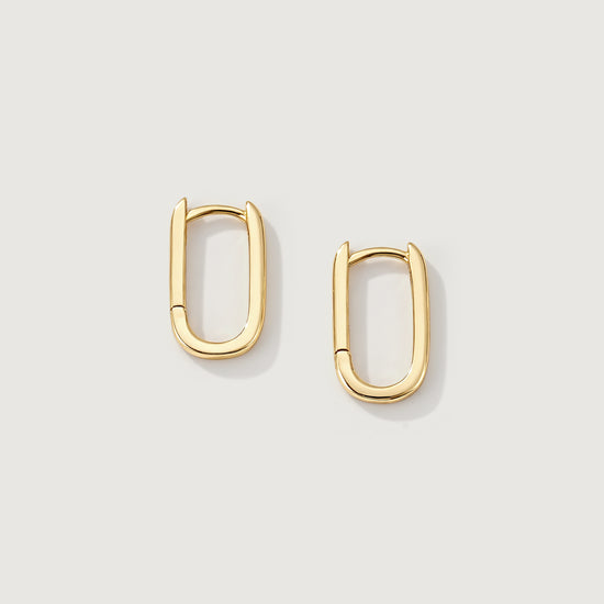 Gold hoop earrings on a light gray background