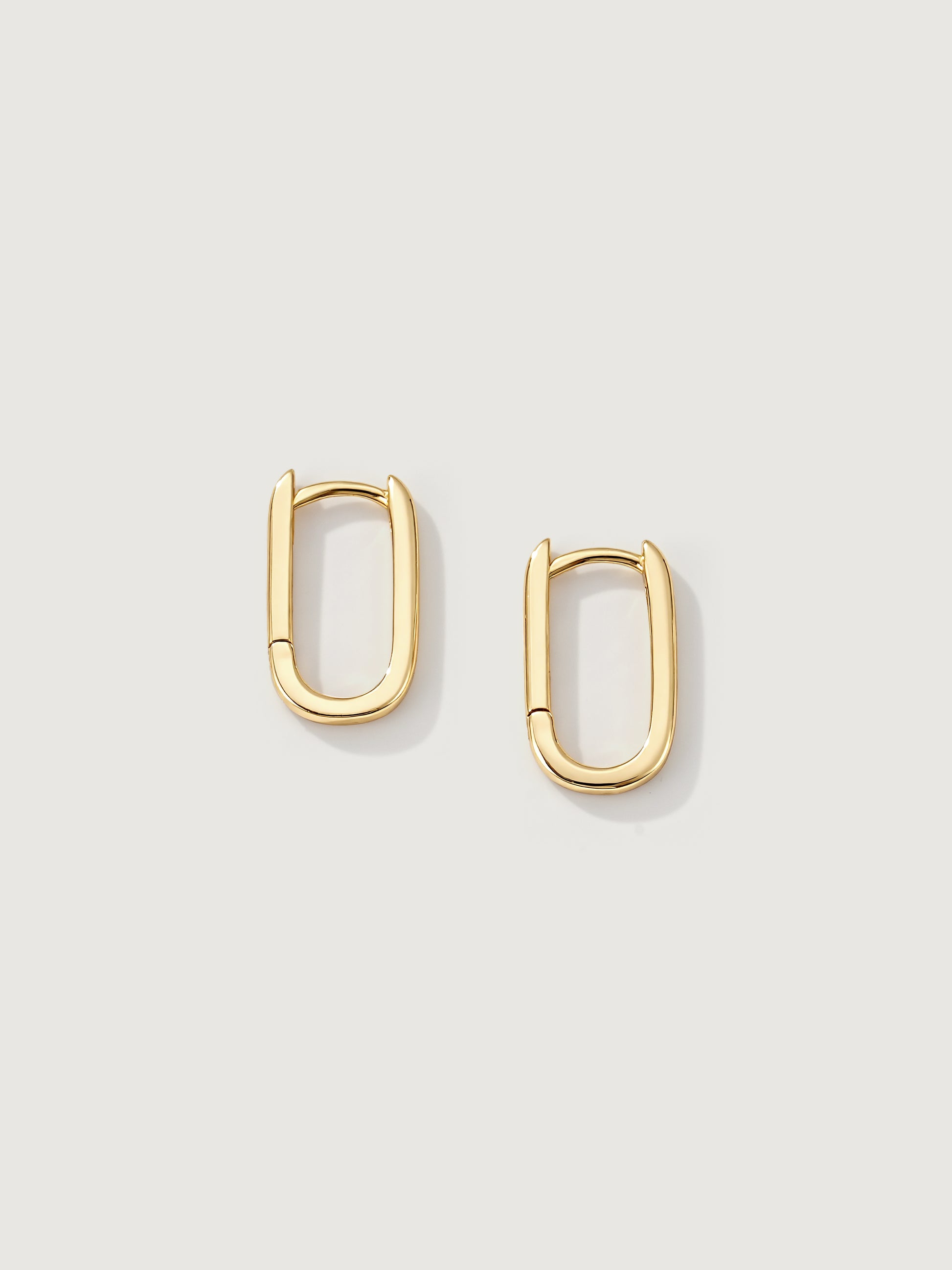 Gold hoop earrings on a light gray background