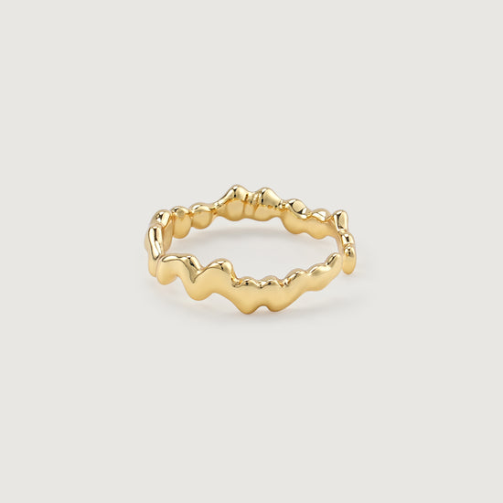 Gold open ring with wavy design on a light gray background