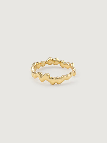 Gold open ring with wavy design on a light gray background