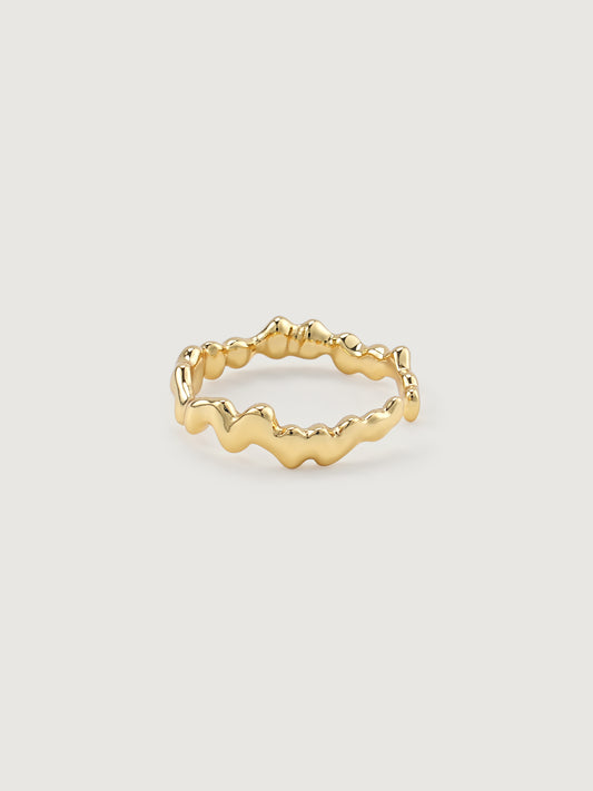 Gold open ring with wavy design on a light gray background