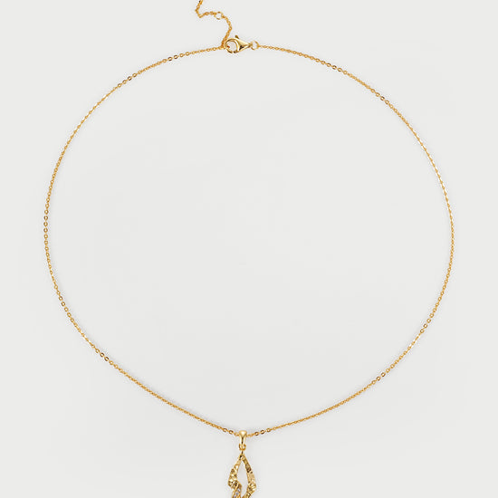 Gold necklace with a pendant on a light gray background