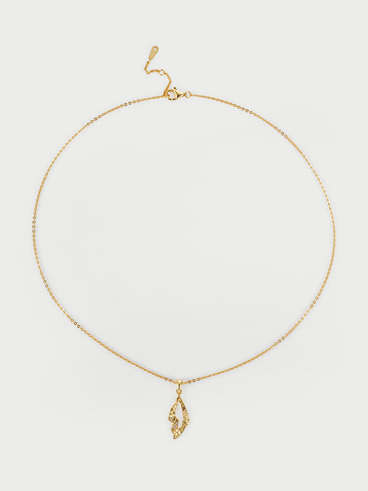 Gold necklace with a pendant on a light gray background
