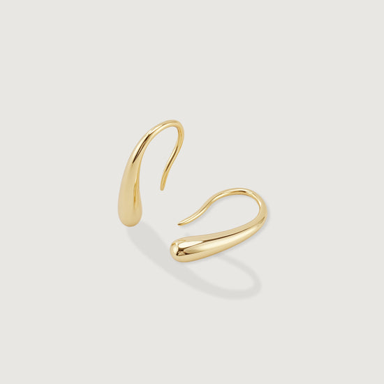 Gold hoop earring on a light gray background