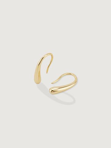 Gold hoop earring on a light gray background