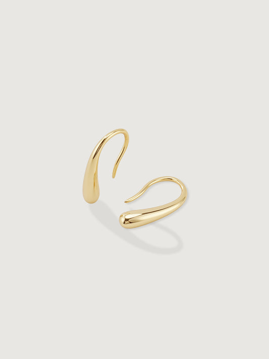 Gold hoop earring on a light gray background
